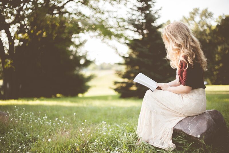 公園で１人で本を読む女性